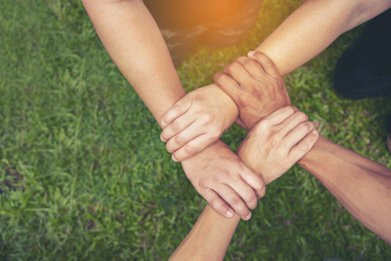 Top View Four hands Diverse multiethnic Partner team together. Close up Teamwork group of Four multiracial people join hands together. Above view Diversity people hand join partner team trust team